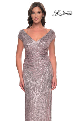 A woman wears a rose-gold, V-neck, cap-sleeve, floor-length sequin sheath dress with a ruched waist, the La Femme 30865.