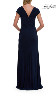 A woman is seen from the back wearing the La Femme 30874 Cap-Sleeve Long Jersey Formal Dress in navy blue, which features cap sleeves, a fitted waist, and a deep V-shaped back for an elegant and refined silhouette.