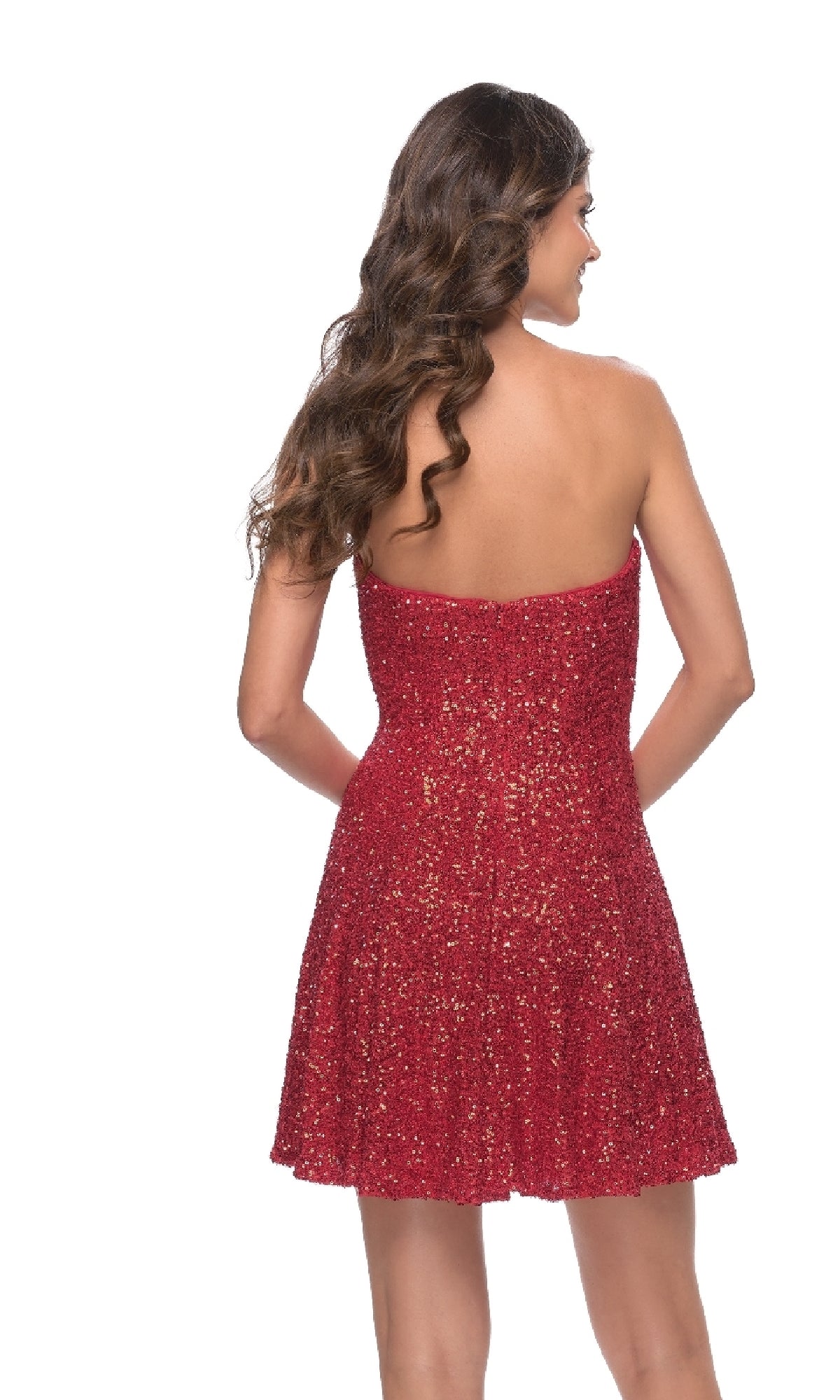 A woman with long wavy hair models the Strapless Sequin Short La Femme Homecoming Dress, shown from the back against a white background.