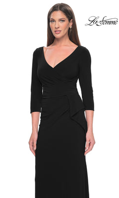 A woman stands against a white background wearing the La Femme Sleeved Simple Jersey Formal Dress 30967, a fitted long black dress with three-quarter sleeves and a V-neck. The "La Femme" logo appears in the top right corner.