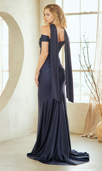 Woman showing the back of a navy evening gown she's wearing in a bright room.