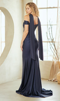 Woman showing the back of a navy evening gown she's wearing in a bright room.