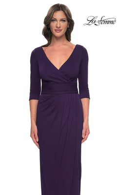 A woman wearing a floor-length, deep purple faux wrap Long Formal Dress: La Femme 31014 with a V-neck, three-quarter sleeves, and a modest formal silhouette.