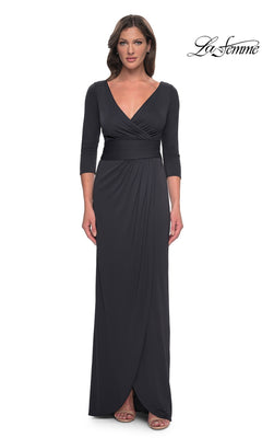 A woman wears a charcoal Long Formal Dress: La Femme 31014, a floor-length jersey V-neck dress with three-quarter length sleeves and a draped skirt.