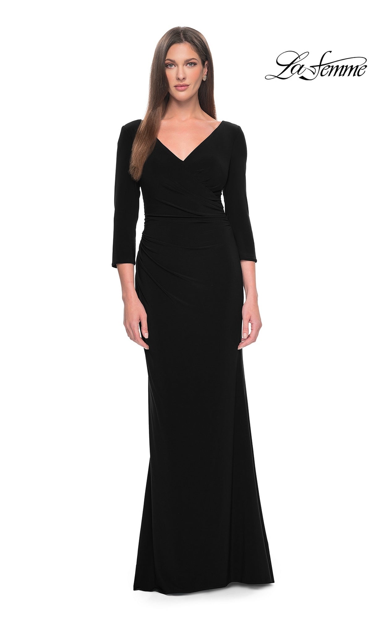Woman wears the La Femme Long-Sleeve Fitted Formal Dress 31020 in black, featuring three-quarter sleeves and a v-neck in sleek jersey fabric, standing against a plain white background with the La Femme logo at the top right.