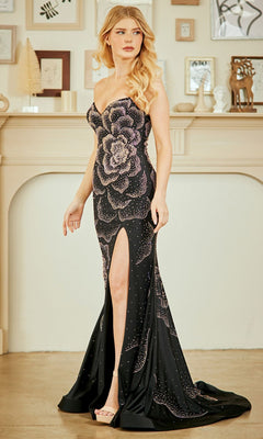 Woman wearing the Strapless Beaded Prom Gown: Amelia Couture 3105, featuring a large floral pattern, thigh-high slit, and sparkling details, standing indoors before a decorated mantelpiece.