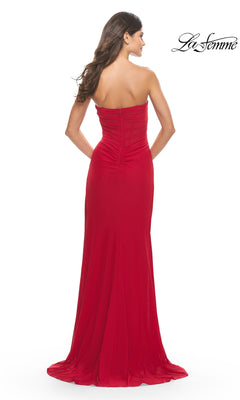 A woman models the Sheer-Bodice Strapless Long La Femme Prom Dress in vibrant red, shown from the back on a plain white background with the "La Femme" logo in the top right corner.
