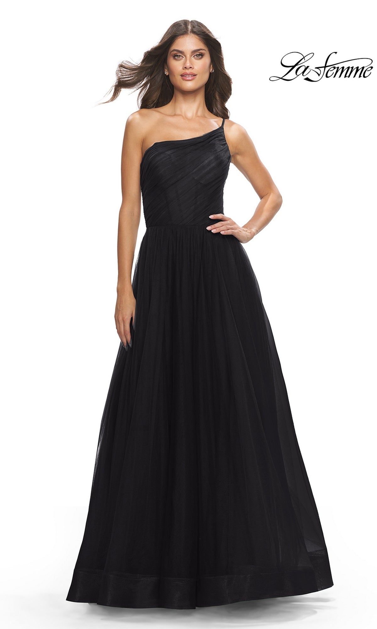 A woman shines in the One-Shoulder Sheer-Bodice Prom Ball Gown 31069, a floor-length black formal dress with a fitted bodice and flowing skirt. The La Femme logo appears in the upper right corner.