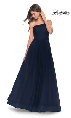A woman smiles as she looks down, wearing the La Femme One-Shoulder Sheer-Bodice Prom Ball Gown 31069—a floor-length, navy blue formal dress featuring a fitted bodice and full skirt.