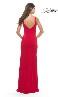 A woman with long, wavy hair models the Classic Long Jersey Prom Dress: La Femme 31071—a sleeveless, floor-length red gown with a deep V-back—shown from behind against a plain white background. Ideal for formal events.