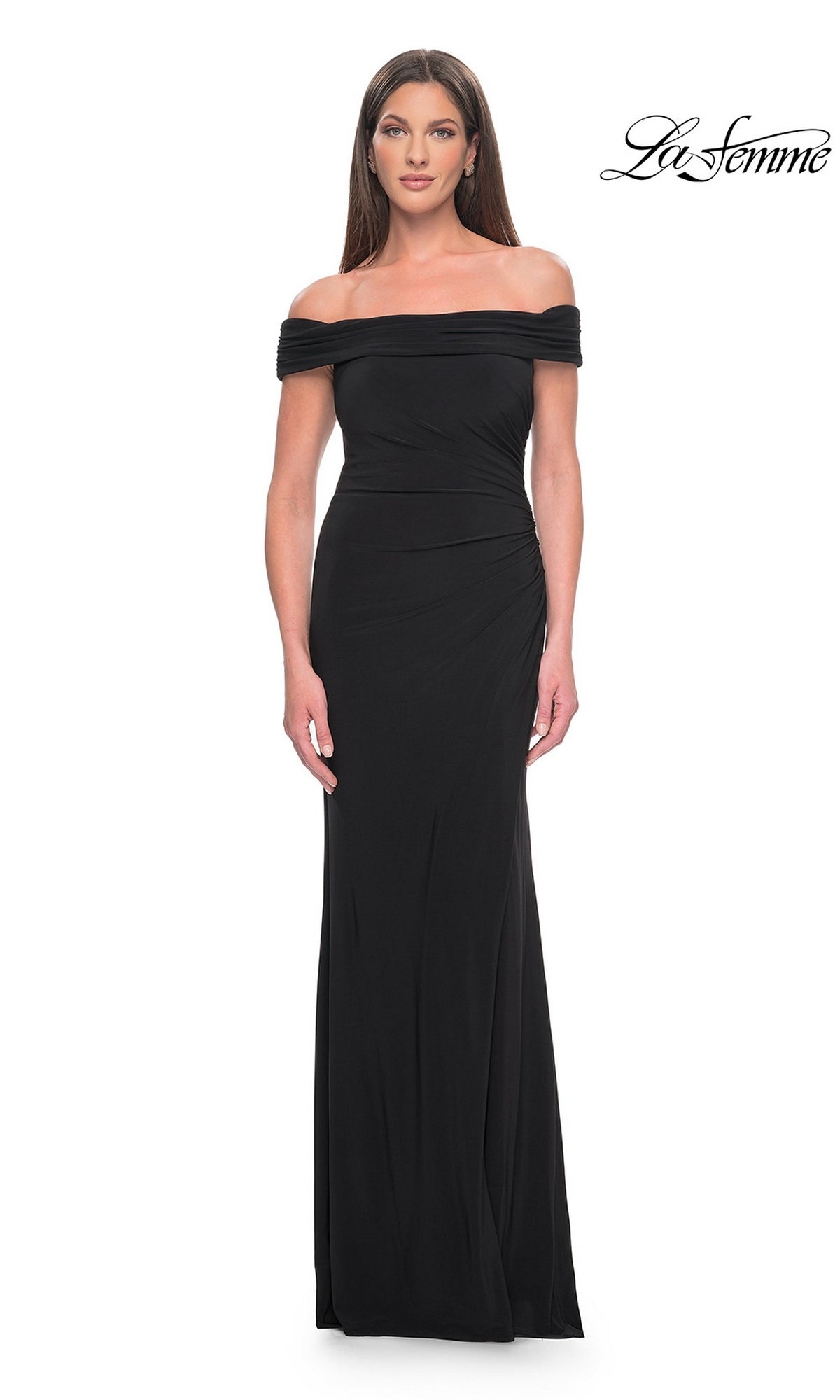 A woman wears a black, off-the-shoulder Long Formal Dress: La Femme 31086, featuring a floor-length silhouette with subtle side ruching.