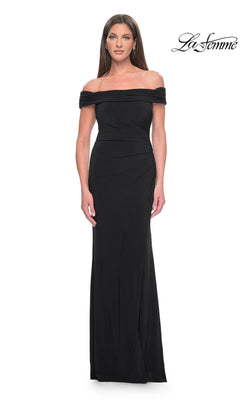A woman wears a black, off-the-shoulder Long Formal Dress: La Femme 31086, featuring a floor-length silhouette with subtle side ruching.