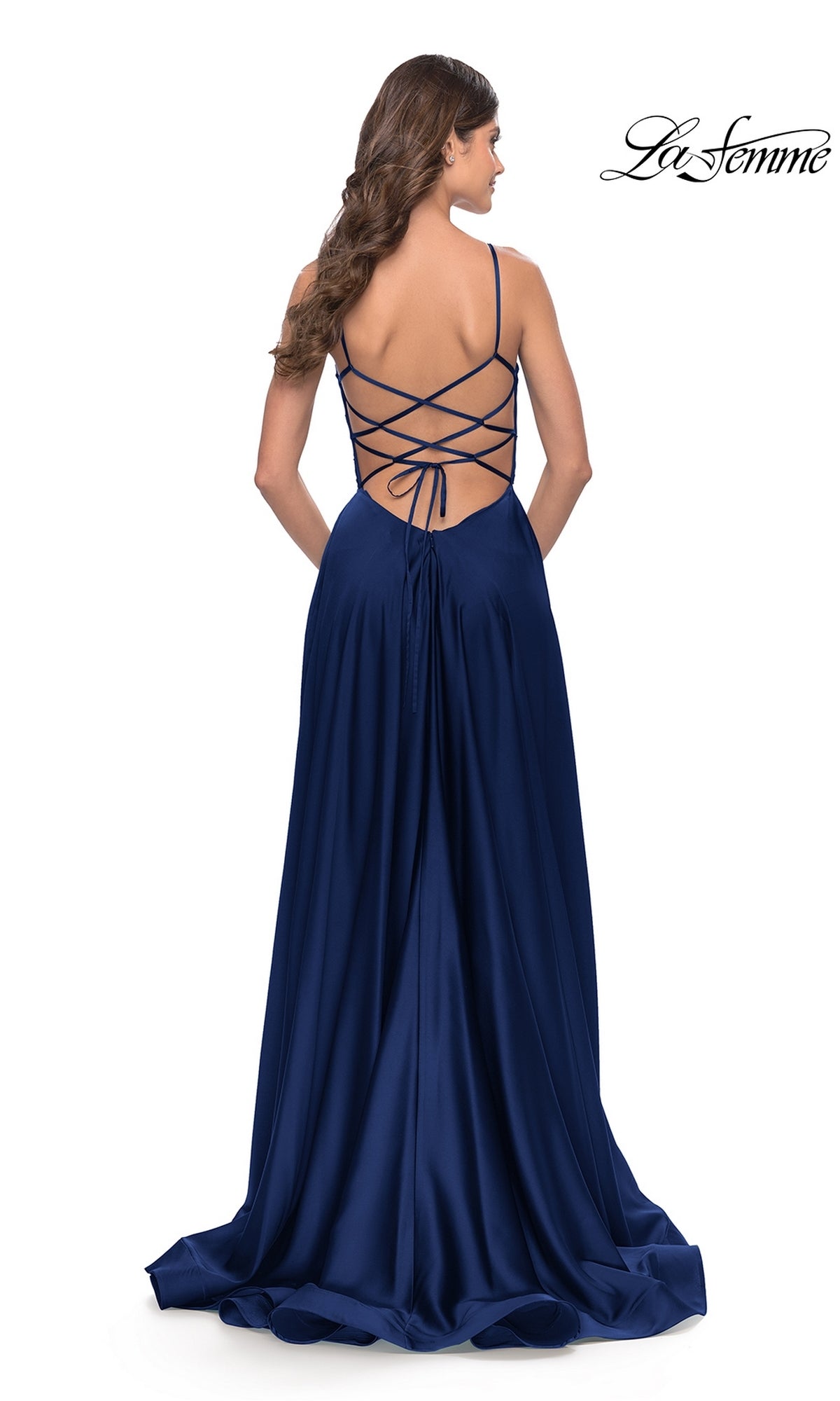 A woman in the Corset-Back La Femme Long A-Line Prom Dress 31105, a floor-length deep blue satin gown with thin shoulder straps, is shown from behind.