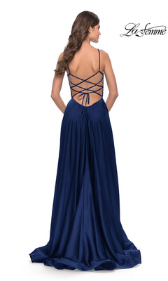 A woman in the Corset-Back La Femme Long A-Line Prom Dress 31105, a floor-length deep blue satin gown with thin shoulder straps, is shown from behind.