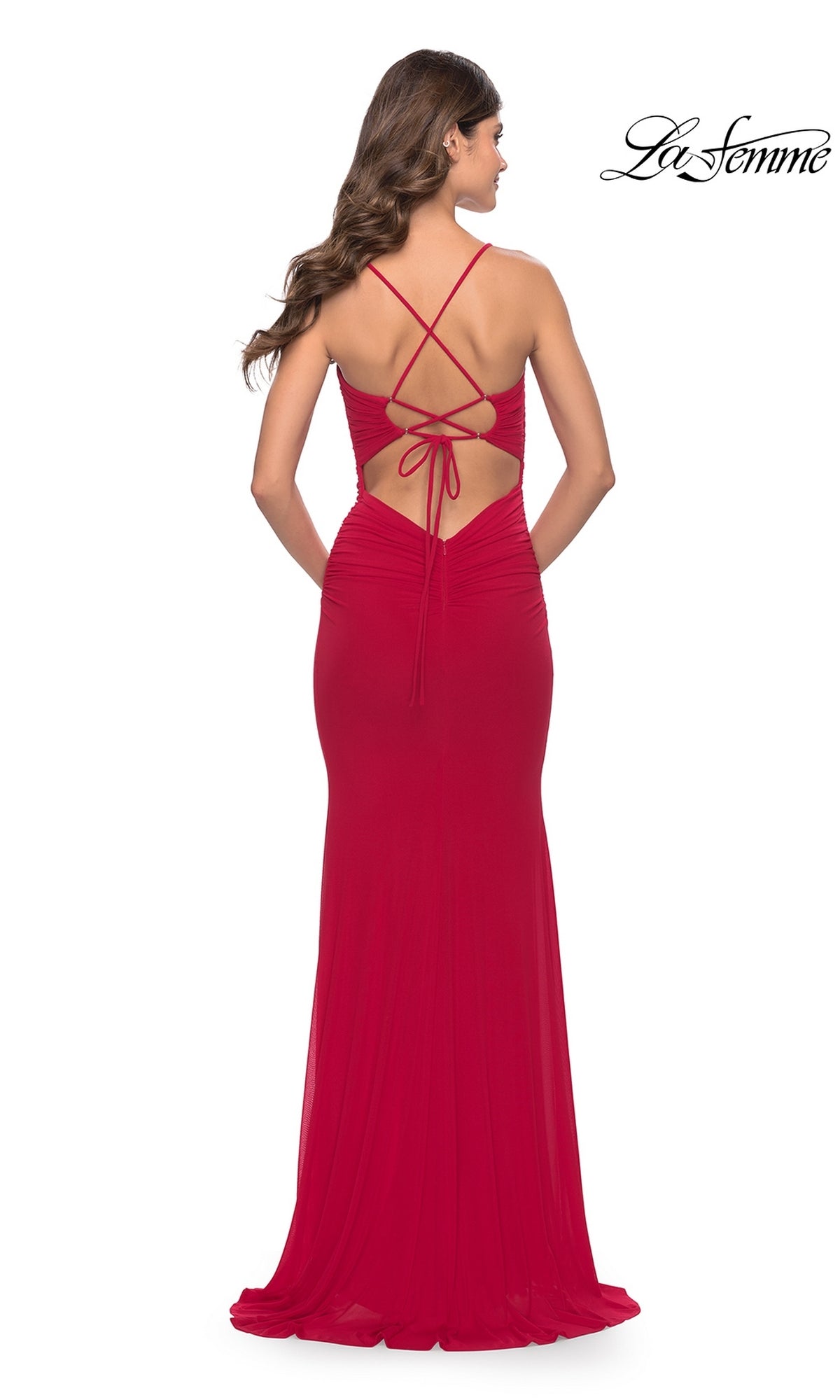 Woman in the Tight La Femme Strappy-Back Long Prom Dress 31114, featuring a floor-length, sleeveless design with a low open back, criss-cross straps, and slight ruching, standing with her back facing the camera.