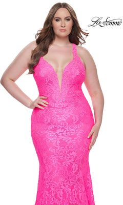 A woman models the La Femme Long Prom Dress 31118, a bright pink sleeveless lace gown with a deep V-neck, against a white background. The "La Femme" logo appears in the top right corner.
