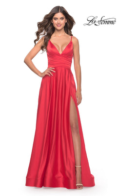 A woman poses in the La Femme Bright Long A-Line Prom Dress 31121, a sleeveless red gown with a deep V-neckline and high leg slit, her hand on her hip. The signature "La Femme" logo appears in the top right corner.