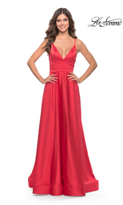 A woman stands with hands on hips against a white background, wearing the La Femme Bright Long A-Line Prom Dress 31121— a stunning red satin gown with a deep v-neck, fitted waist, and floor-length full A-line skirt.