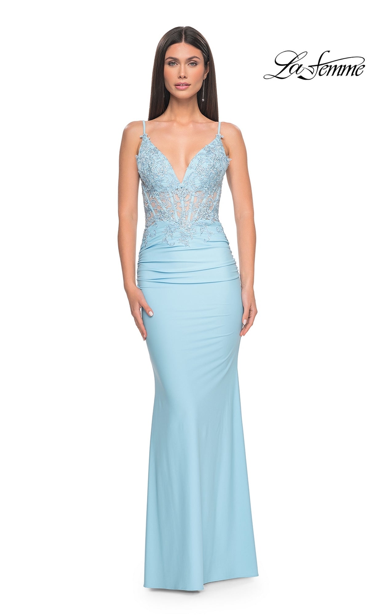 A woman wears the La Femme Sheer-Waist Long V-Neck Prom Dress 31128 in cloud blue, featuring a lace-embroidered bodice with thin straps and a flowing skirt. The La Femme logo is displayed in the top right corner.