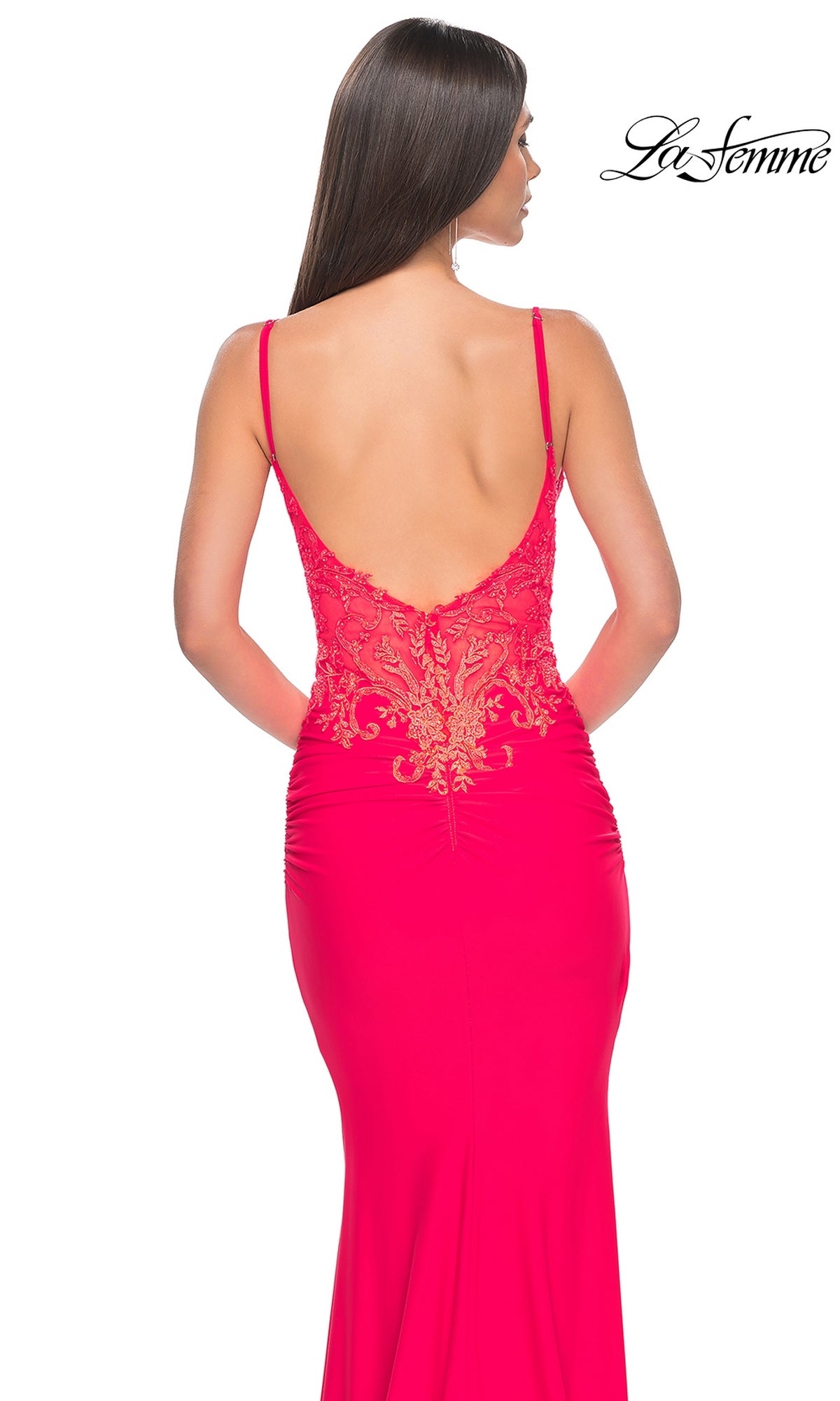 A woman is seen from behind wearing the La Femme Sheer-Waist Long V-Neck Prom Dress 31128 in bright pink, featuring a gold embroidered-lace bodice; the 