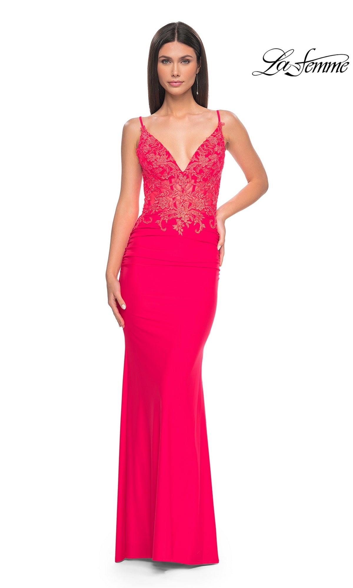A woman wears the La Femme Sheer-Waist Long V-Neck Prom Dress 31128 in hot coral, featuring a fitted embroidered-lace bodice, deep V-neckline, and floor-length sleeveless silhouette for a glamorous, form-fitting look.