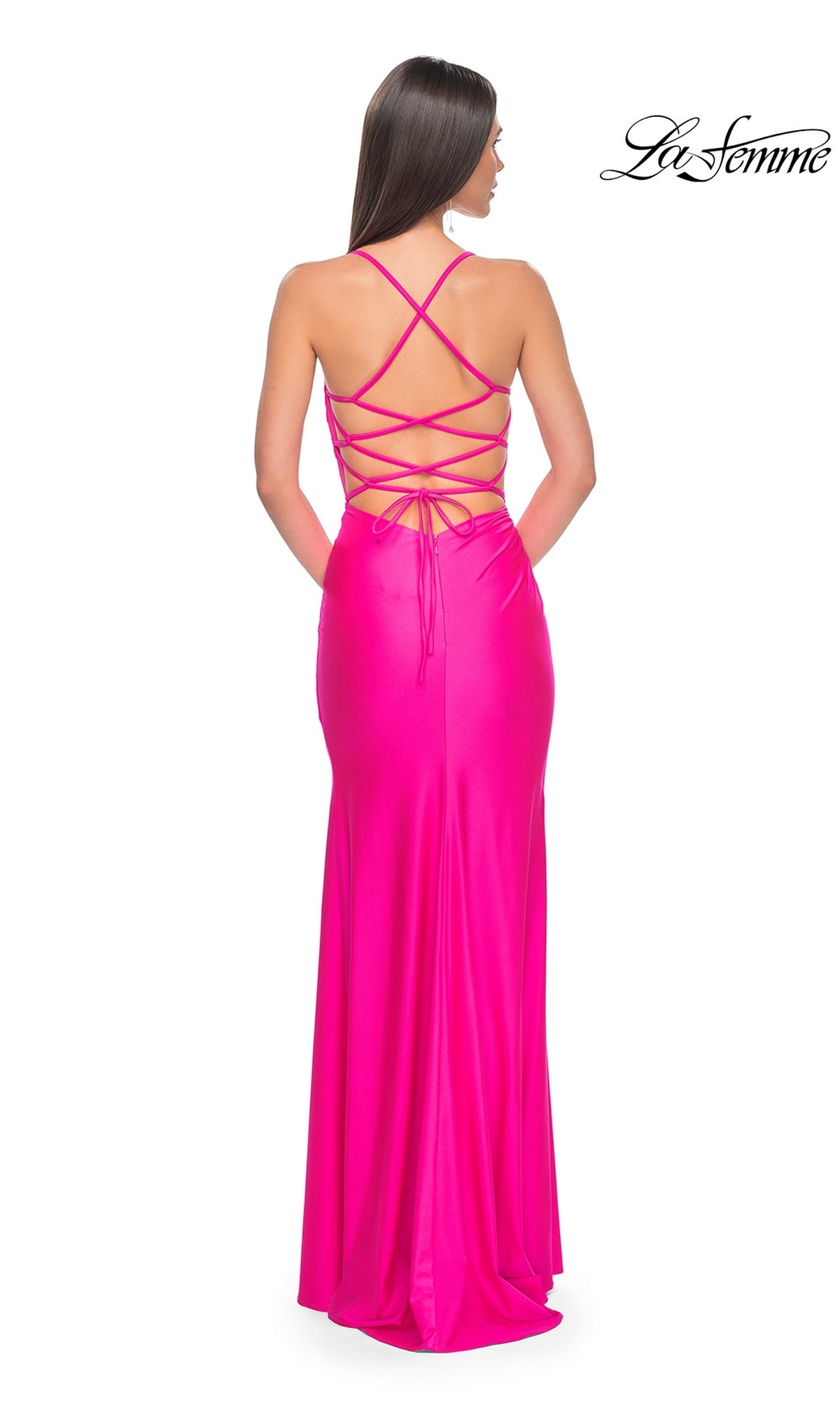 A woman faces away from the camera in the La Femme Strappy Open-Back Long Prom Dress 31129, a bright pink gown featuring a strappy open back. The 
