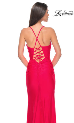 Woman in a bright pink La Femme Corset-Back Long Prom Dress 31131 with crisscross lace-up back, standing with her back to the camera.