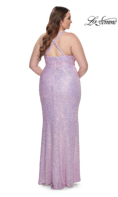 A woman in the La Femme Long Prom Dress 31162—a floor-length, light purple sequin gown with a fitted silhouette and crisscross back straps—stands facing away from the camera.