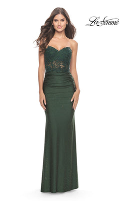 A woman wears the Lace-Bodice Strapless La Femme Prom Dress 31180, a dark green gown with lace detailing on the bodice and a fitted, floor-length skirt. The La Femme logo appears in the top right corner.