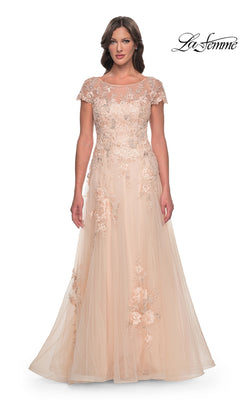 La Femme 31198 is a champagne-colored floor-length gown featuring a sheer neckline, cap sleeves, and beaded lace appliques on an A-line tulle skirt.