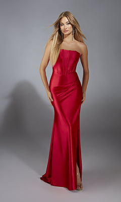 A woman poses against a plain gray background wearing the Aerie Couture 311 Strapless Corset Prom Dress—floor-length red satin with a slit—and long earrings.
