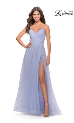A woman wears the La Femme A-Line Long Tulle Prom Dress 31204 in light lavender, featuring spaghetti straps, a V-neckline, and a high slit. She stands with one hand on her hip, smiling. The La Femme logo is in the corner.