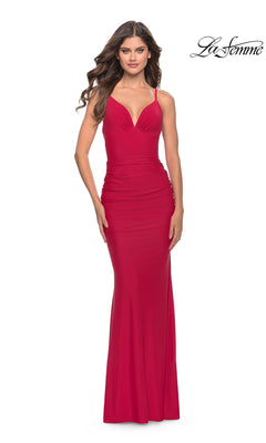 A woman models the Simple V-Neck La Femme Designer Prom Dress 31227, a fitted red sleeveless gown with thin straps, standing before a plain white background. The "La Femme" logo is visible in the top right corner.