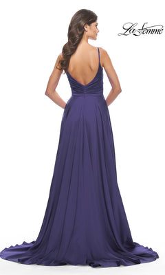 A woman with long wavy hair models the La Femme Open-Back A-Line Designer Prom Dress 31233 in deep purple, featuring thin straps and a low V-back, against a white background.