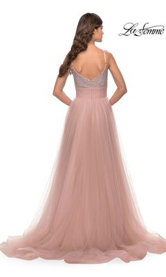 A woman is seen from the back in the Beaded-Bodice Tulle Prom Ball Gown 31238, a blush pink La Femme dress with a fitted, beaded bodice, spaghetti straps, v-neckline, and a flowy tulle skirt for an elegant look.