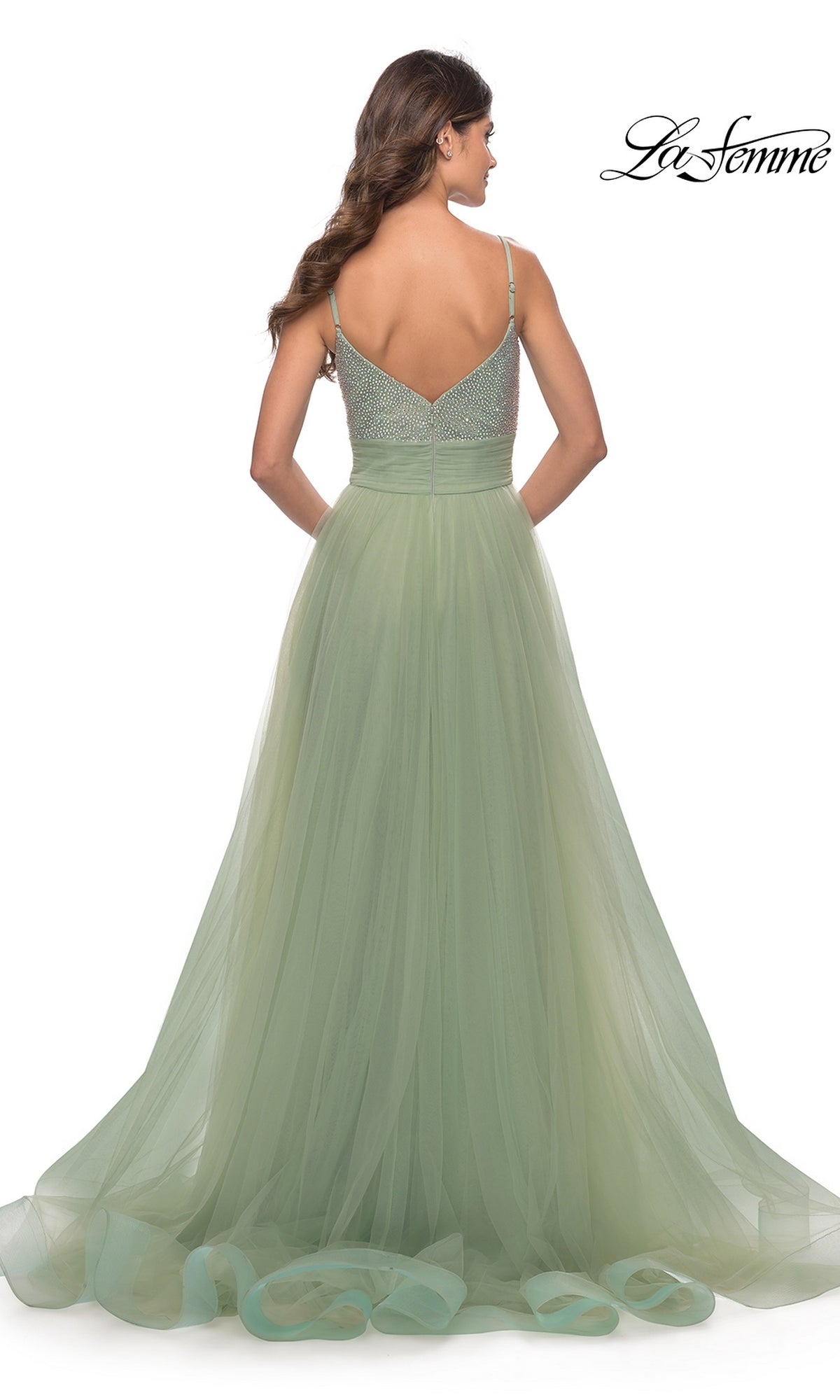 Woman in a light green, floor-length Beaded-Bodice Tulle Prom Ball Gown 31238 with thin straps, shown from the back against a white background. 