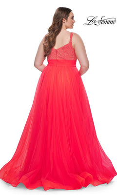 A woman with long brown hair is shown from the back wearing the La Femme Long Prom Dress 31251, a plus-size gown with a beaded bodice and flowing tulle skirt.