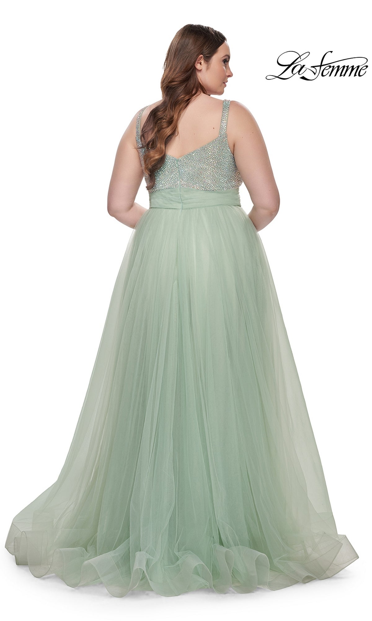 A woman shown from the back wearing the La Femme Long Prom Dress 31251, a plus-size style featuring a beaded bodice and flowing tulle skirt.