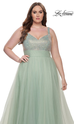 A woman poses in front of a white background with the "La Femme" logo, wearing the mint green La Femme Long Prom Dress 31251—plus-size with a beaded bodice and flowing tulle skirt.
