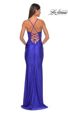 A woman is seen from behind wearing the La Femme Sheer-Corset Tight Long Prom Dress 31272 in royal blue, featuring a floor-length fit, embroidered-lace bodice, lace-up back, and thin crisscross straps.
