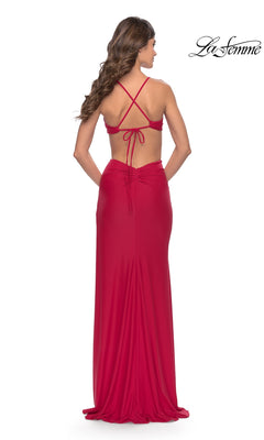 A woman wearing a La Femme 31292 long prom dress, a floor-length red gown with a crisscross open back and side cutouts.