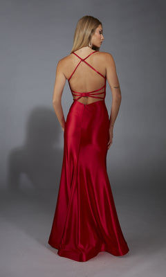 A woman wearing the Aerie Couture 312 long prom dress, featuring red satin fabric and a strappy open back, stands facing away against a plain gray background.