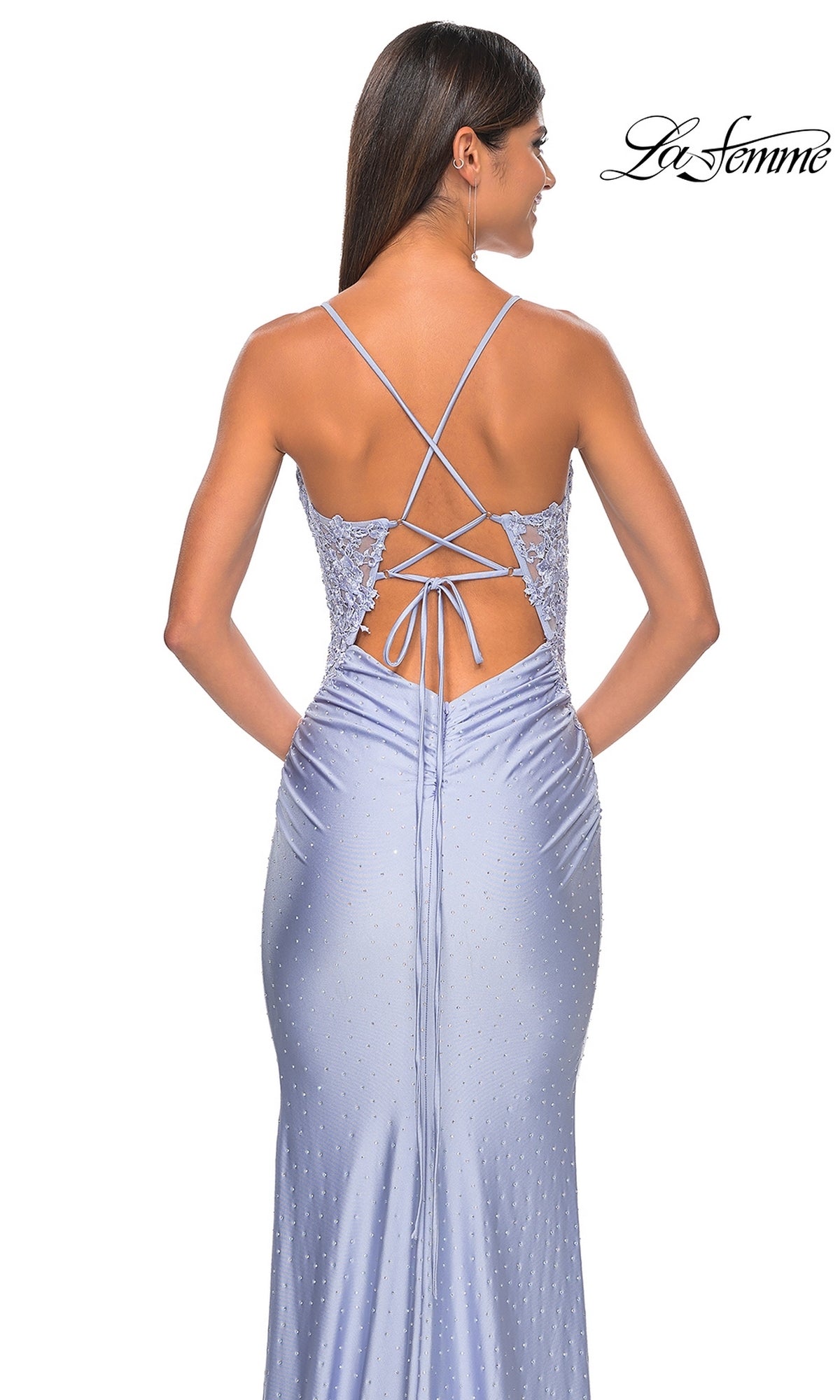 Woman wearing a light purple Lace-Side La Femme Long Beaded Prom Dress 31301 with thin straps, showing off the lace-up back detail as she stands with her back to the camera.