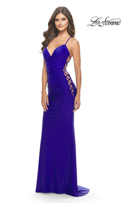 A woman stands against a white background wearing the La Femme Lace-Up-Sides Long Prom Dress 31315—a floor-length royal blue gown with spaghetti straps and side lace-up detailing.