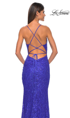 A woman wears the La Femme Long Beaded Lace Prom Dress 31359, a royal blue, sequin-embellished, form-fitting gown with an open lace-up back and floor-length design. The La Femme logo is in the top right corner.