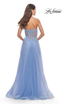 A woman wears the La Femme Strapless Sheer-Waist Prom Dress 31367 in light blue, featuring a strapless neckline, sheer lace-embroidered back, and a flowing A-line tulle skirt.