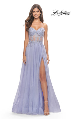 A woman stands smiling in the La Femme Strapless Sheer-Waist Prom Dress 31367, a lavender gown with a sheer bodice, lace embroidery, high leg slit, and an elegant A-line tulle skirt.