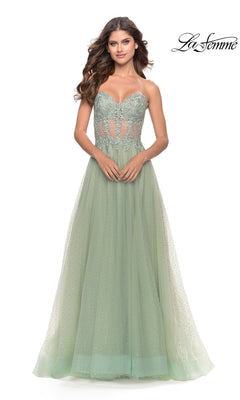 A woman models the La Femme Strapless Sheer-Waist Prom Dress 31367, a pale green gown with a sheer lace-embroidered bodice and flowing A-line tulle skirt. The "La Femme" logo is displayed in the top right corner.