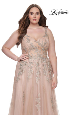 A woman models the La Femme Long Prom Dress 31383, a sleeveless blush embroidered lace gown with silver floral details, standing against a white background. The La Femme logo is in the top right corner.