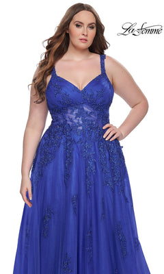 A woman stands against a white background in the La Femme Long Prom Dress 31383, a royal blue plus-size prom gown featuring sleeveless design and floral lace details.